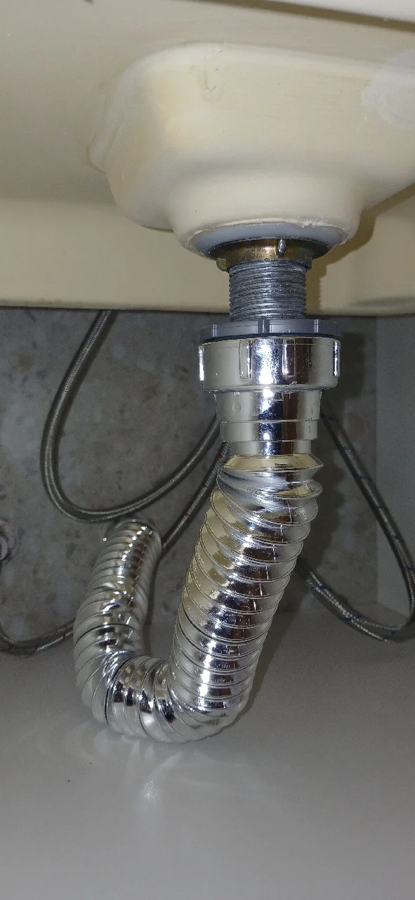 Sifão flexível novo instalado sob cuba de banheiro